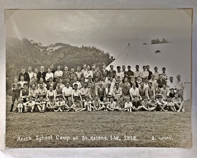 Four rows of eighty-four boys and staff, the front cross-legged on the ground, the second seated and the third and fourth standing