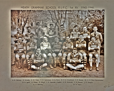 Formal photograph showing eight people standing in the back row, seven people sitting and two seated on the ground in the front