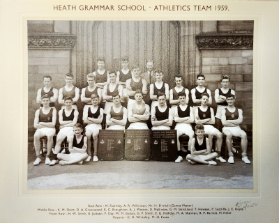 Formal photograph showing one row seated and two rows standing with two boys crosslegged on the ground in front of the seaten row