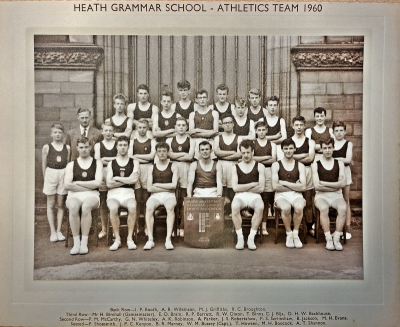 Formal photograph showing team members standing in three rows on the front steps behind seven seated team members
