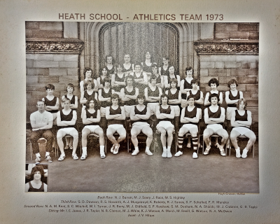 Formal photograph showing team members in two rows standing on the front steps of the school behind seven seated team members