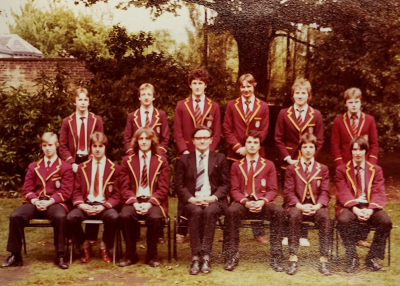 Six prefects standing behind six seated prefects with Mr Crosby in the middle of the seated row