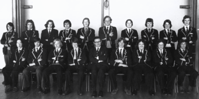 One rows of boys standing behind one row of boys seated with Mr Crosby in the middle of the seated row