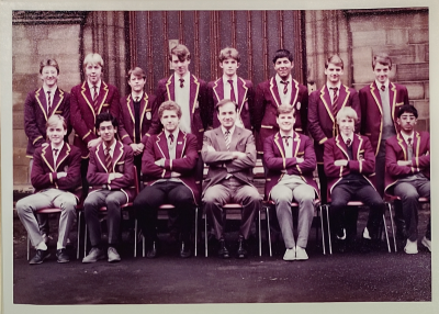 Eight prefects standing behind six seated prefects with Mr Crosby in the middle of the seated row