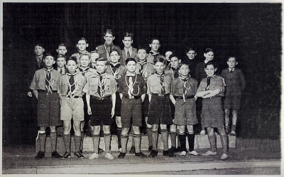 Three rows of scouts in uniform standing on a stage