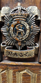 The letters RASC entwined surrounded by ‘Honi soit qui mal y pense,’ a laurel wreath and rays of the sun surmounted by a crown with RASC underneath