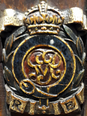 Monarch’s initials surrounded by a belt and a laurel wreath surmounted by a crown with RE underneath