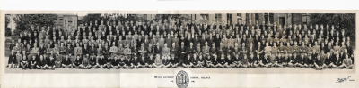 All the pupils and teachers of the school arranged in six rows with a row of boys cross-legged in front of the masters and prefects and the remainder in the rows behind