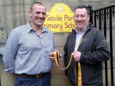 Jon Hamer and Jim Farrell holding a ribbon in the schools’ colours, claret and gold, in front of Heath school