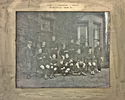 Formal photograph showing six players standing behind six variously seated players with Mr Jennings to the left and Mr Wheatley to the right