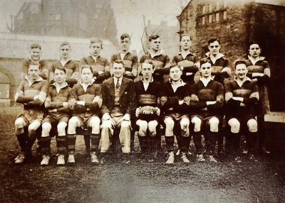 Formal photograph showing eight players standing behind seven seated players with Mr Bilbrough seated to the left of the Captain