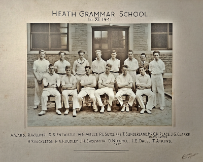 Formal photograph showing thirteen players in two rows of seven standing and six sitting with Mr Place second right on the back row
