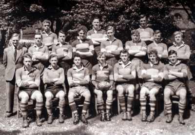 Formal photograph showing seventeen players of the 1951/52 Rugby Team in three rows of seven, seven and three from front to back with Mr Burchall to the left of the middle row