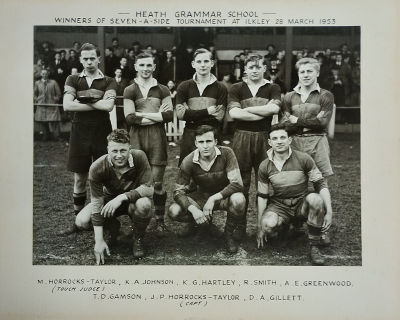 The touch judge and four players standing behind three seated players