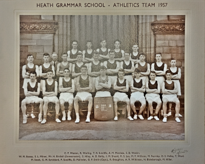 Formal photograph showing five athletes standing behind a row of ten standing athletes with Mr H. Birchall third from the left behind nine seated athletes