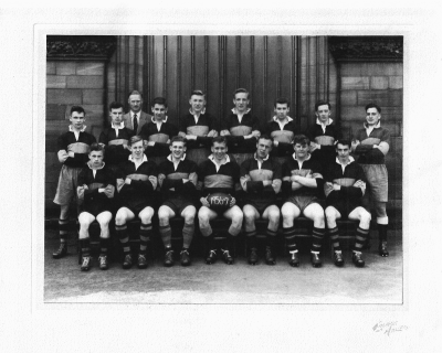 Formal photograph showing fifteen players in two rows of seven seated and eight standing with Mr H. Birchall behind the back row to the left