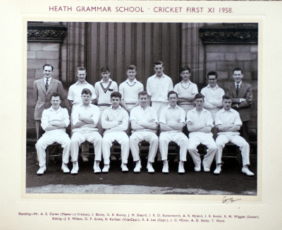 Formal photograph showing eleven players of a 1950s Cricket Team in two rows of five seated and six standing with the scorer and Mr A.E. Carter behind the back row