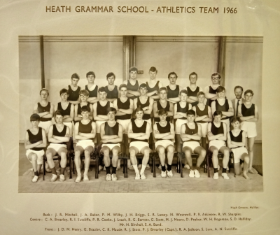 Formal photograph teaken indoors showing team members standing in two rows behind nine seated team members