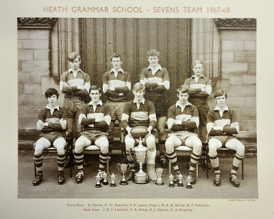 Formal photograph showing four team members standing on the front steps behind five seated team members