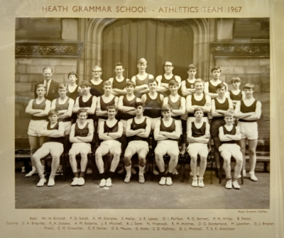 Formal photograph showing team members standing in two rows on the front steps behind seven seated team members