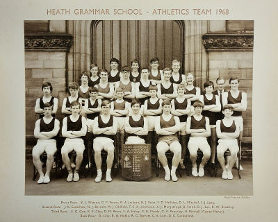 Formal photograph showing team members in three rows standing on the front steps of the school behind seven seated team members