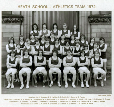 Formal photograph showing team members in three rows standing on the front steps of the school behind seven seated team members