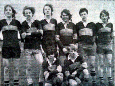 Two rows of boys in rugby kit, six standing and two kneeling in front of them