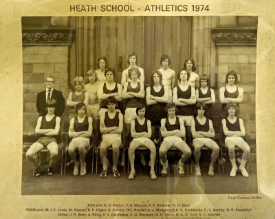 Formal photograph showing team members in two rows standing on the front steps of the school behind seven seated team members