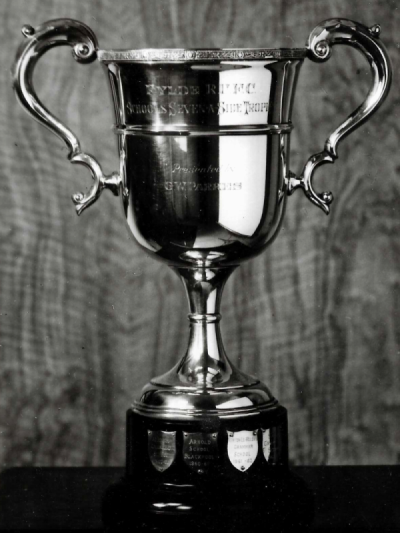 Photograph showing an vase-shaped trophy inscribed ‘Schools seven a side trophy’ on a stand